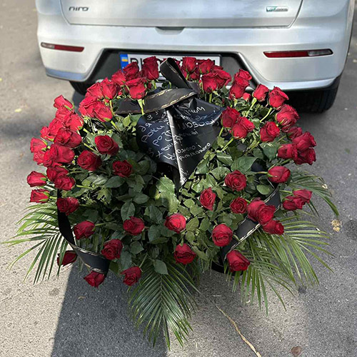 сто червоних троянд у кошику фото траурного букета